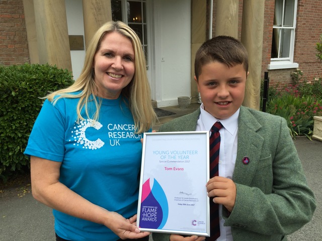 Louise Aubrey from Cancer Research presents Tom Evans with his Flame of Hope award.