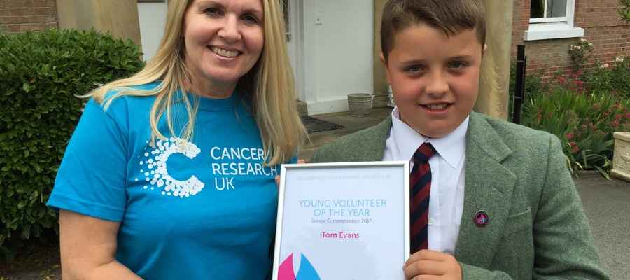 Louise Aubrey from Cancer Research presents Tom Evans with his Flame of Hope award.