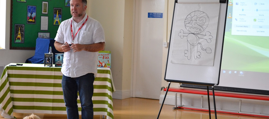Curtis Jobling demonstrates how to draw Raa Raa the Noisy Lion for pupils at The Elms